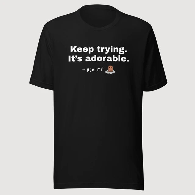 Reality — Keep trying. It’s adorable. on a black Bella + Canvas 3001 T-shirt, front mockup
