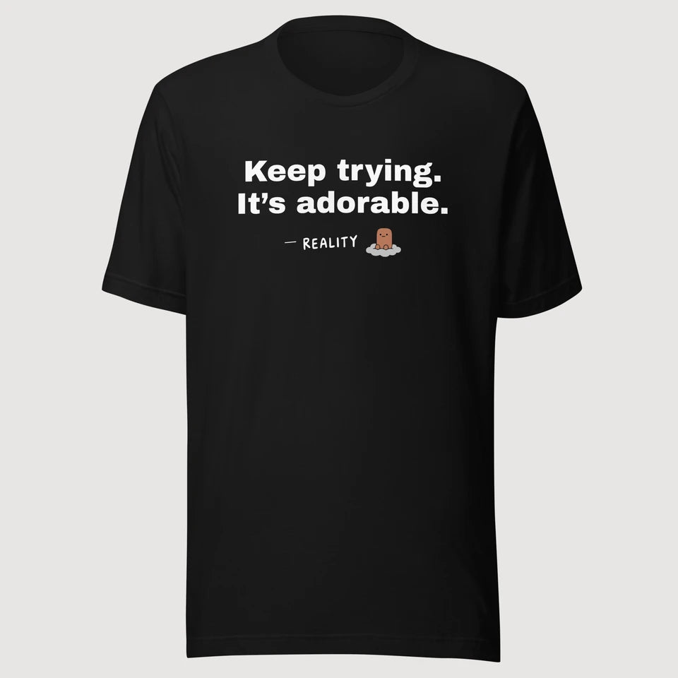 Reality — Keep trying. It’s adorable. on a black Bella + Canvas 3001 T-shirt, front mockup